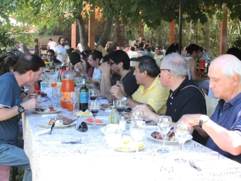 Invitados almorzando en una mesa larga al aire libre
