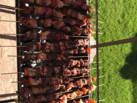 Brochetas de carne asándose en una parrilla vertical