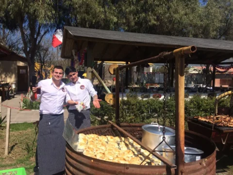 Equipo de servicio junto a una olla de acompañamientos al aire libre