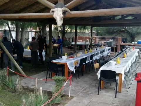 Mesas montadas bajo un quincho para un almuerzo