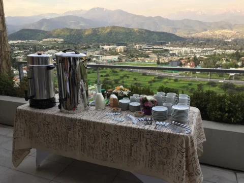 Mesa de café montada en una terraza con vista a la cordillera