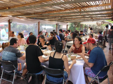 Invitados compartiendo un desayuno bajo una pérgola