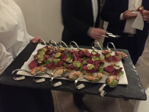 Garzón ofreciendo una bandeja de bocados en una fiesta de graduación